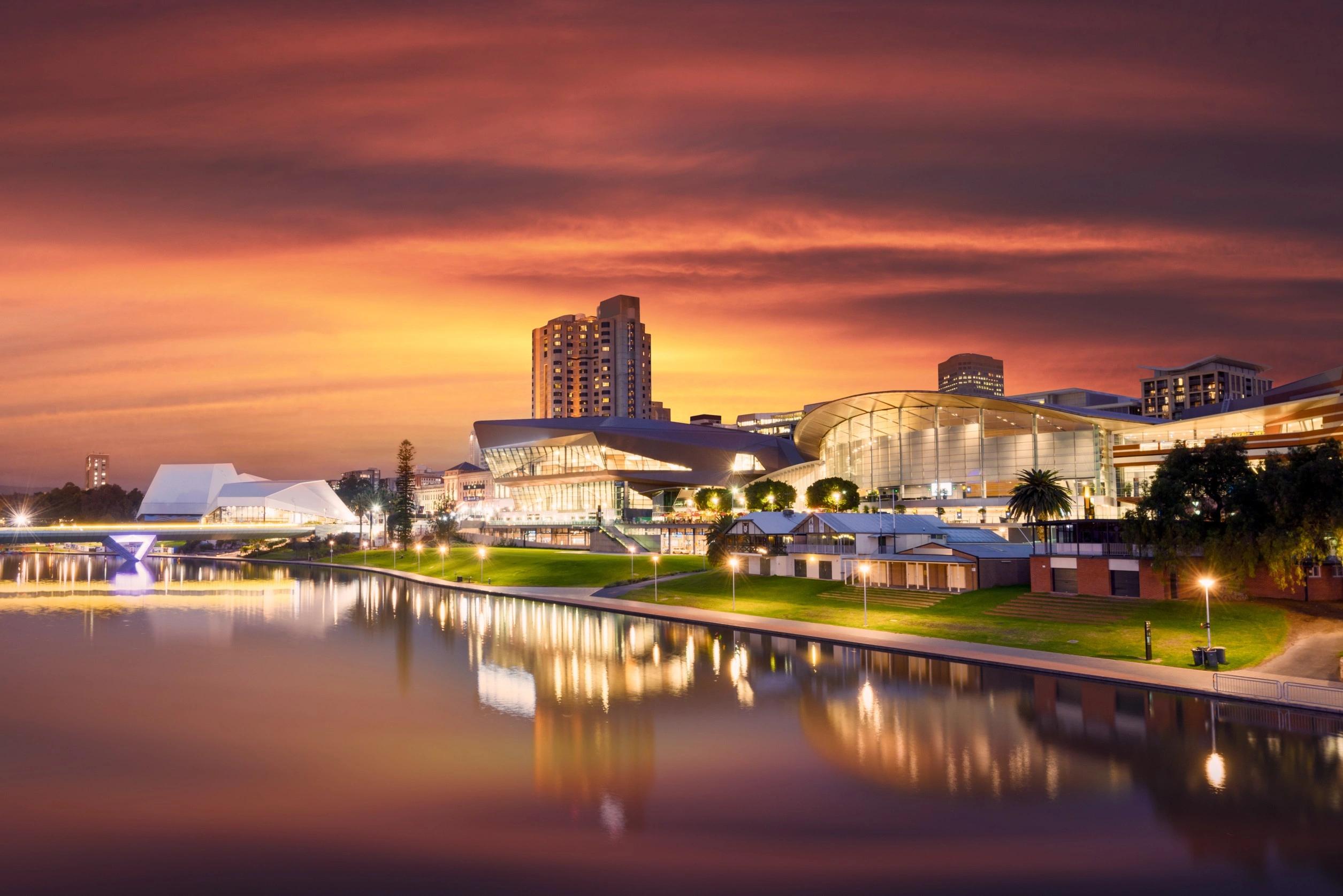 Adelaide city waterfront lit up at sunset reflected in River Torrens