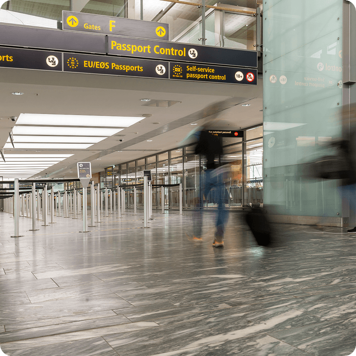 Traveller walking through airport passport control area with luggage