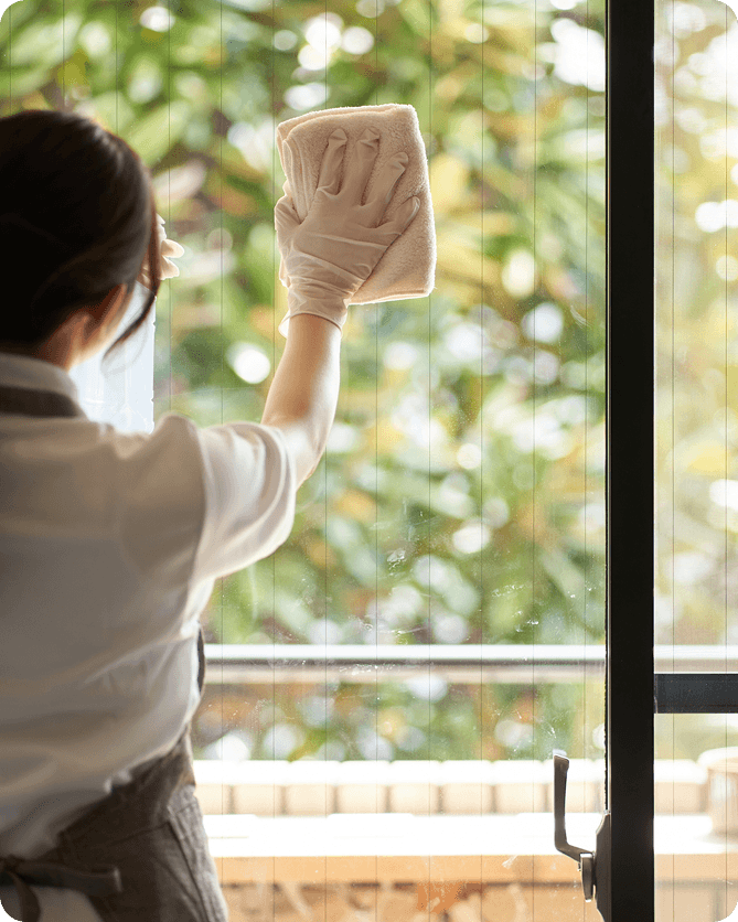 Cleaner wiping glass window with cloth and gloves