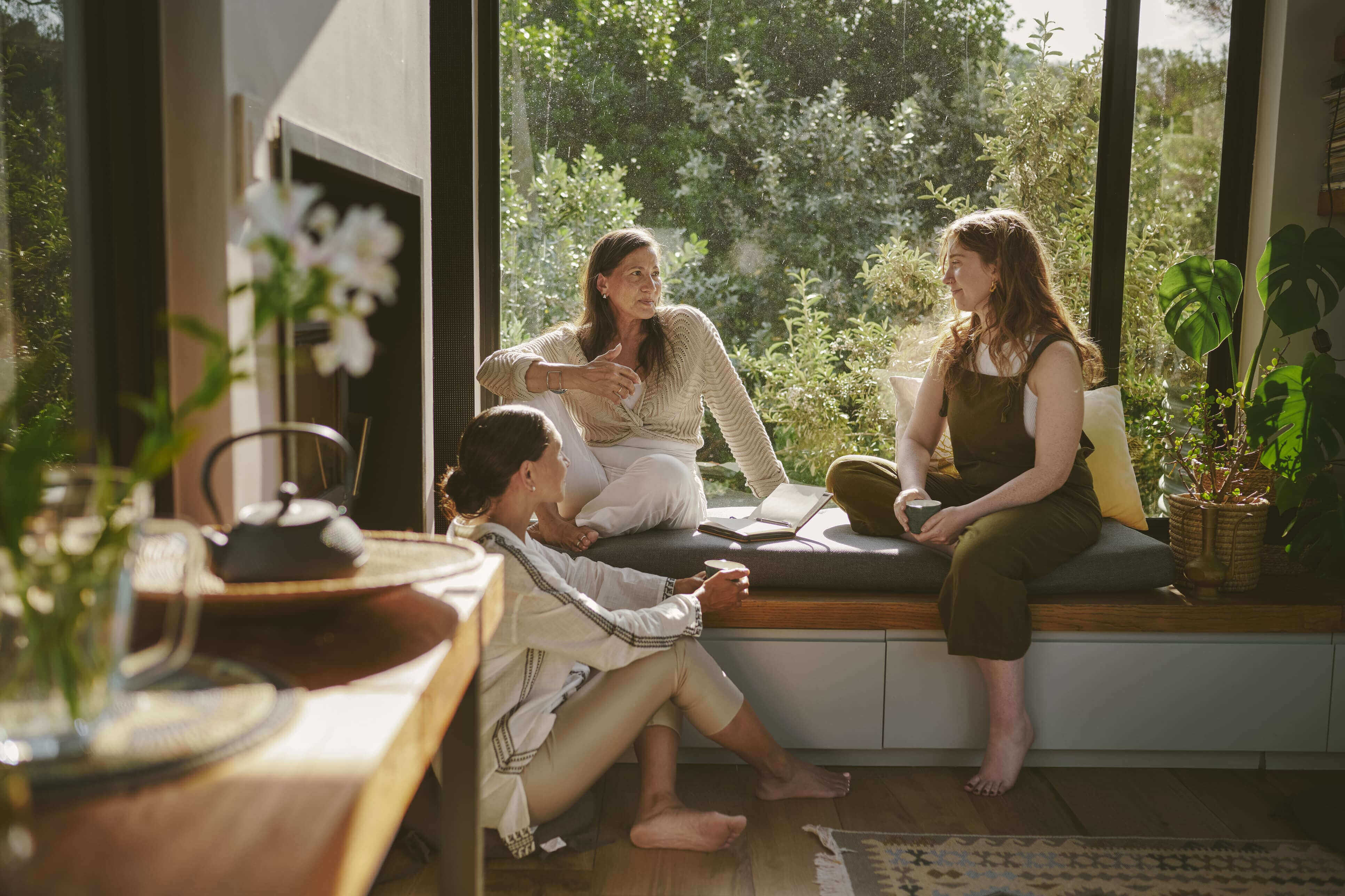 Family members sitting together and talking in bright living room of new home