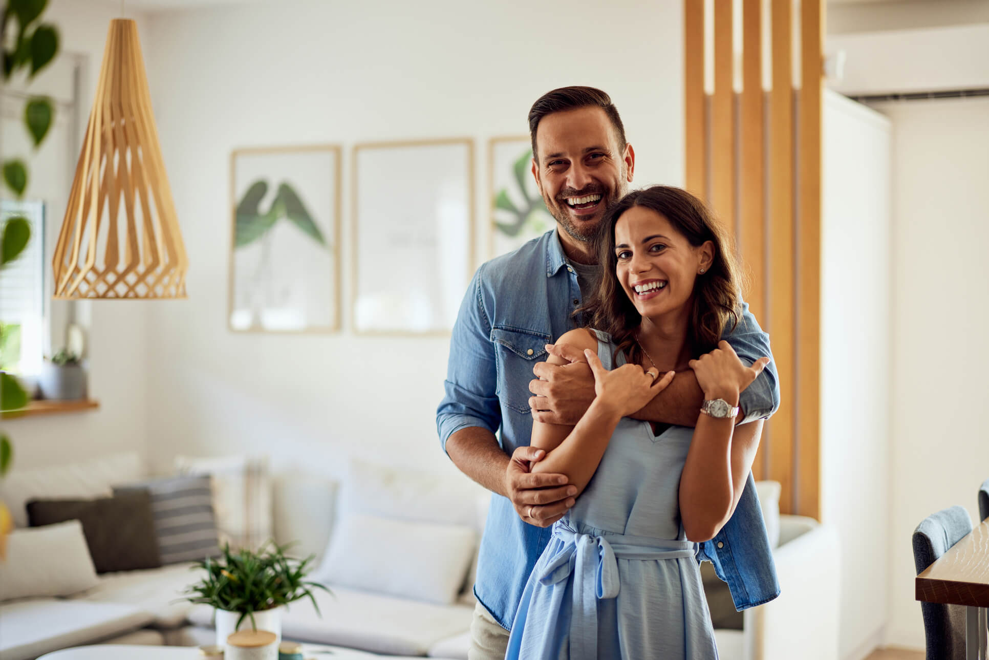 Happy couple embracing and smiling in their new home