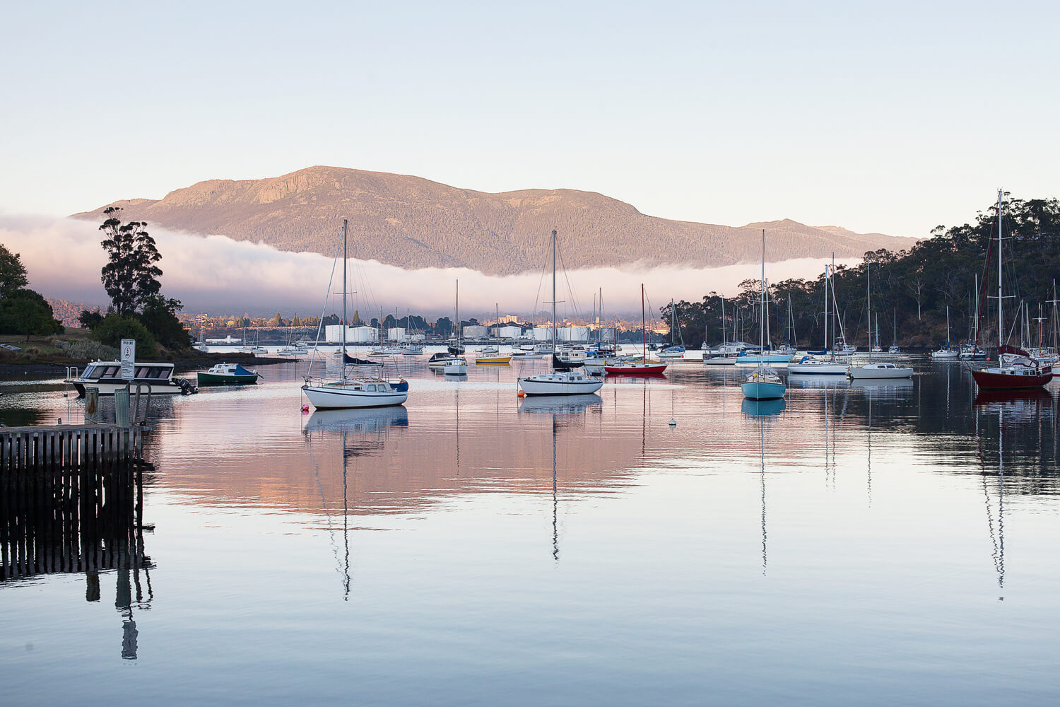 Boats anchored at Hobart waterfront with Mount Wellington in background