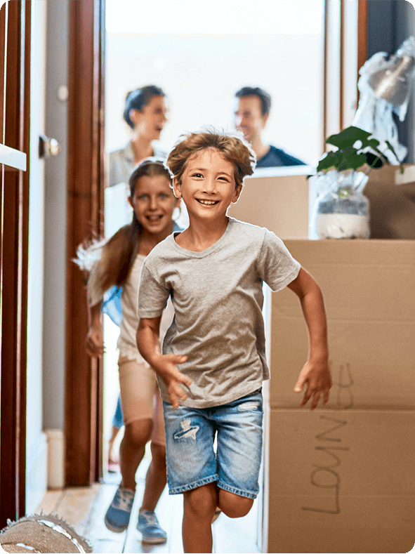 Children running excitedly into new home during family moving day