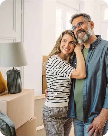 Happy couple standing together inside new home after moving in