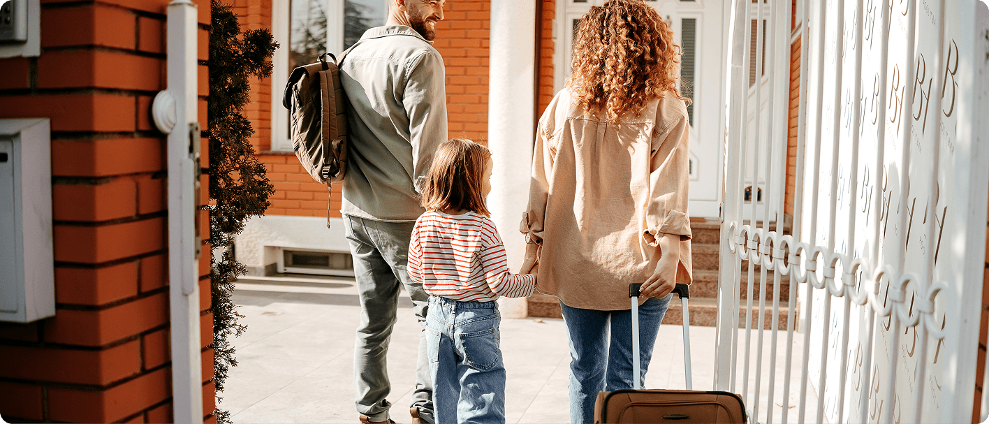 Family entering new home with luggage during house relocation