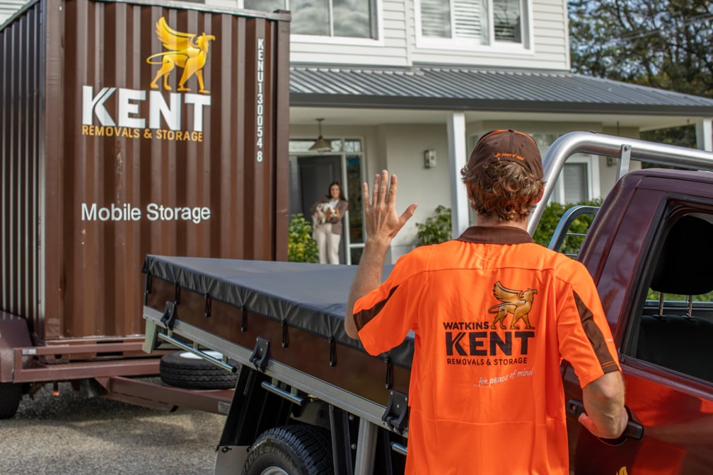 Watkins Kent removals worker waving at customer outside house