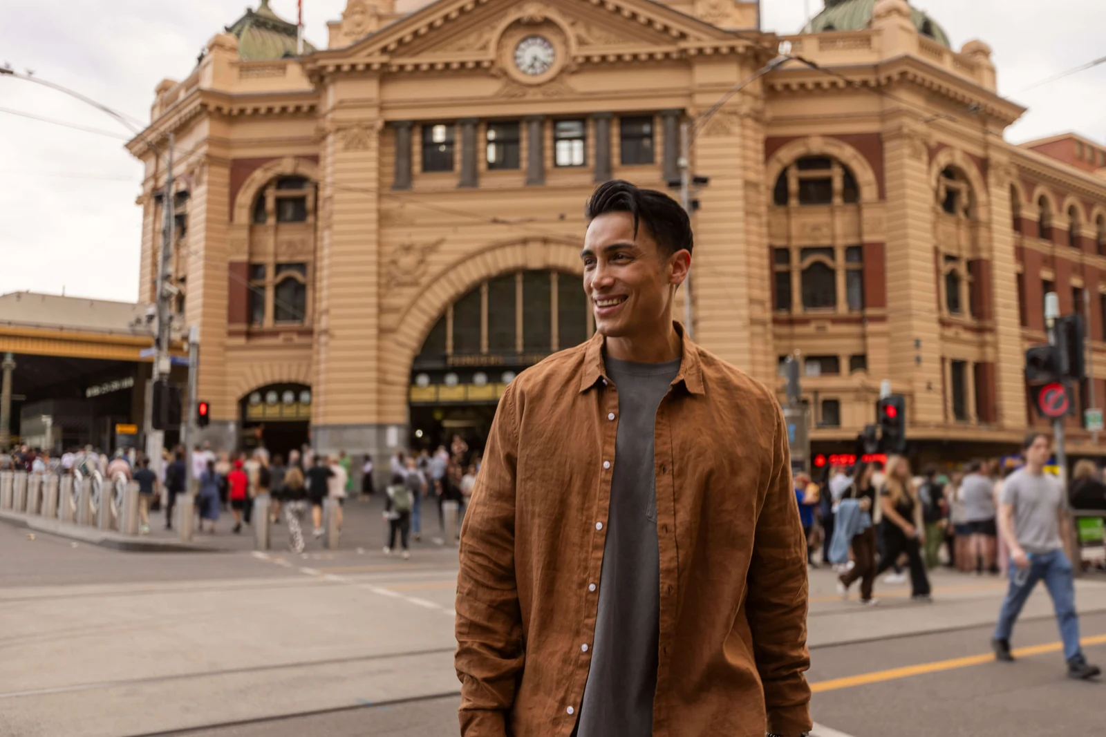Smiling man standing in front of Flinders Street Station in Melbourne